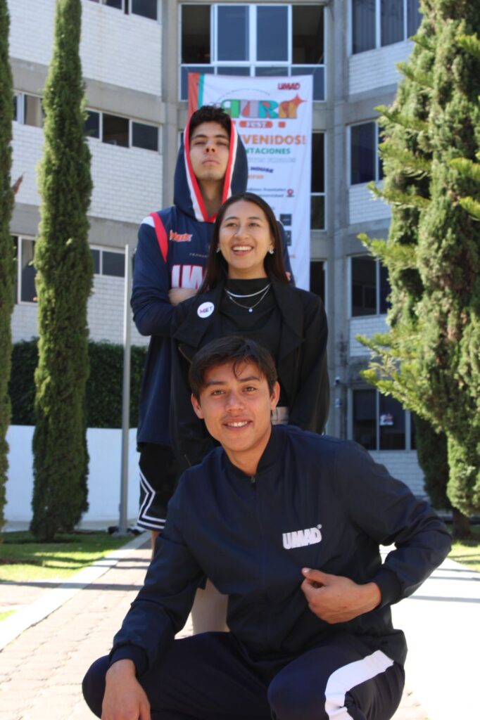 Karla Valero posa con dos estudiantes del equipo de basquet.