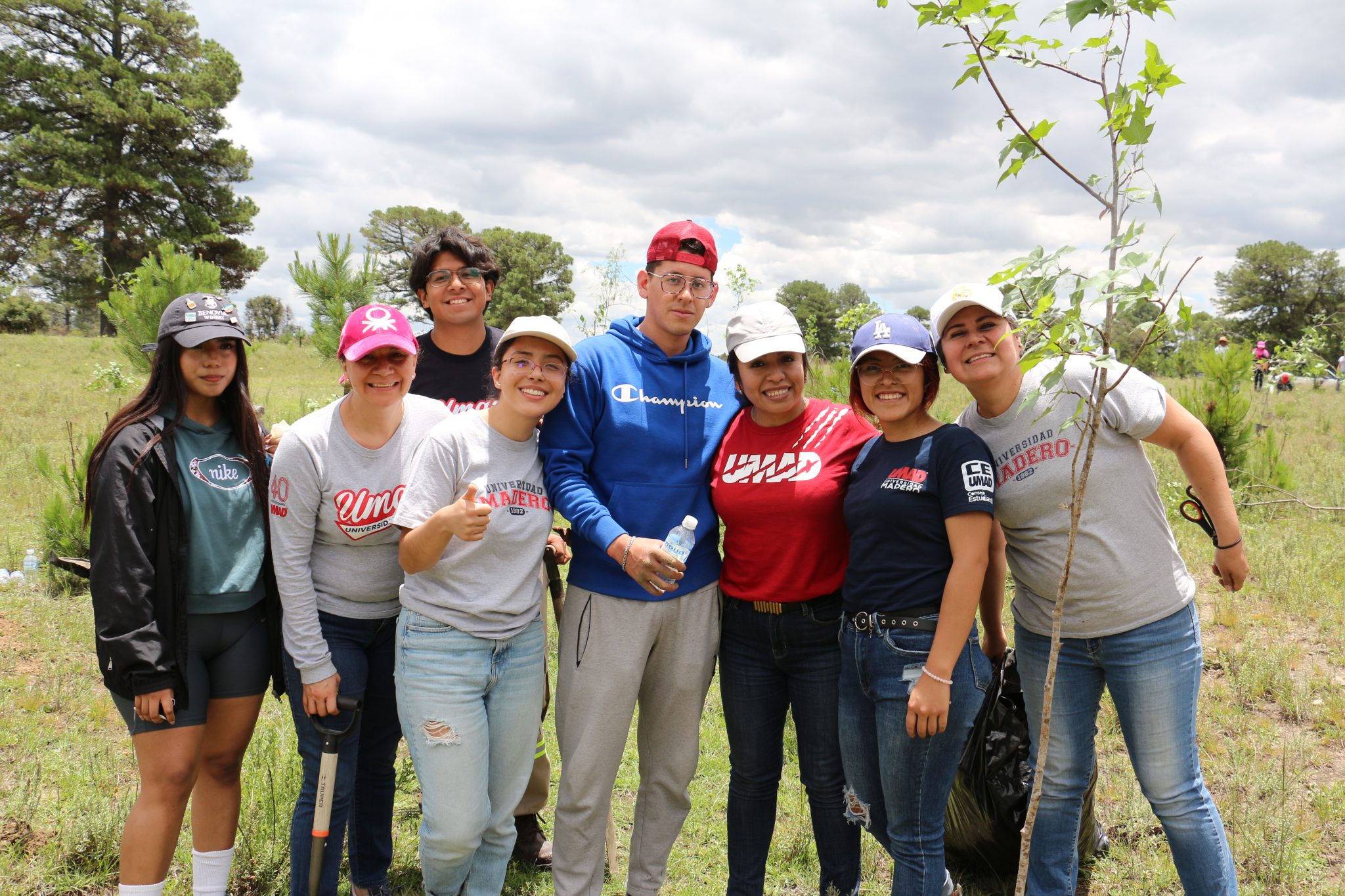 Voluntariado UMAD plantando árboles como parte de su compromiso ambiental.