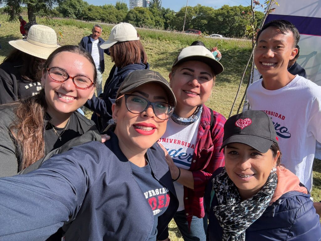 Equipo del Voluntariado UMAD posa frente a los árboles plantados durante la campaña.